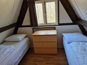Dos camas en una habitación pequeña con dos ventanas. en Charming chalet in Durby with patio, en Septon