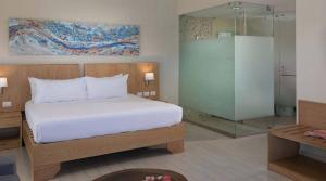 Junior Suite all inclusive luxury and tranquility by Lifestyle Resort في Maggiolo: غرفة نوم مع سرير ودش زجاجي +17 صورة