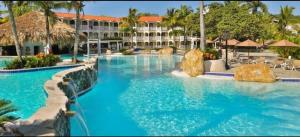 Junior Suite all inclusive luxury and tranquility by Lifestyle Resort في Maggiolo: مسبح بمياه زرقاء في منتجع