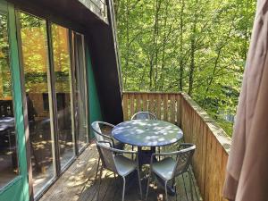 una mesa y sillas en un porche con mesa en Charming chalet in Durby with patio, en Septon