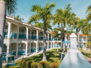 Junior Suite all inclusive luxury and tranquility by Lifestyle Resort في Maggiolo: منظر خارجي للمنتجع مع النخيل