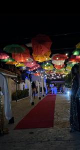 Junior Suite all inclusive luxury and tranquility by Lifestyle Resort في Maggiolo: سجادة حمراء مع مظلات معلقة فوقها