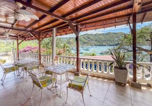 Hotel Bahia Taganga في تاجانجا: شرفة مع طاولات وكراسي وإطلالة على الماء