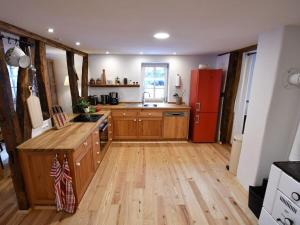 une cuisine avec du parquet et un réfrigérateur rouge dans l'établissement Ferienhaus Steffens, à Mörz 17 autres photos