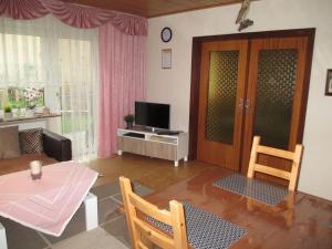 een woonkamer met een tafel en een televisie bij Hehner 2 Comfortable holiday residence in Patersberg