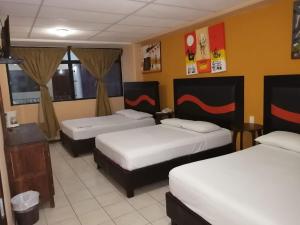 a hotel room with three beds in it at Hotel Tradicional Savaro SA de CV in Zihuatanejo +29 photos