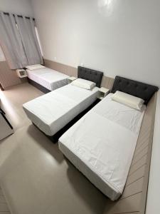two beds in a small room with two bedsvisor at Hotel Rubão in Marabá