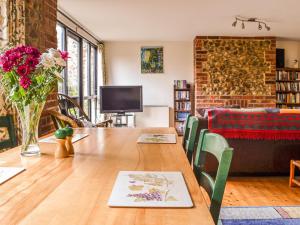een woonkamer met een tafel en een bank bij Owl Barn in Sidestrand