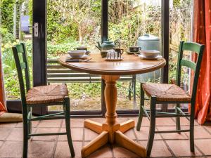 een houten tafel en stoelen op een veranda bij Owl Barn in Sidestrand +12 foto's