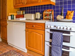 a kitchen with a stove and a white oven at Owl Barn in Sidestrand +8 photos