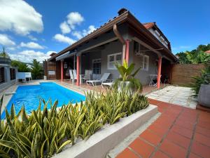a house with a swimming pool in front of it at Maison de vacance 2 Chambres à 200m de la plage in Sainte-Anne