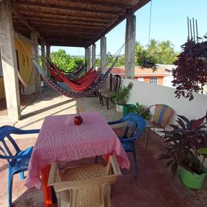 um pátio com uma mesa, cadeiras e uma rede de descanso em Hospedaje Mar Adentro em Puerto Limón