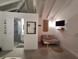 Maison cosy à Sainte-Anne - 31 m² avec terrasse في Douville: غرفة معيشة مع أريكة وتلفزيون