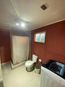 Un pequeño baño con inodoro y ventana. en Departamento francisca, en Tey