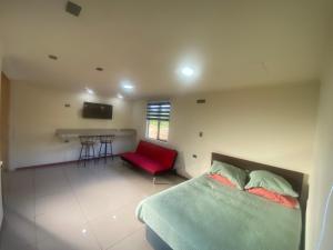 Un dormitorio con una cama y un sofá rojo. en Departamento francisca, en Tey
