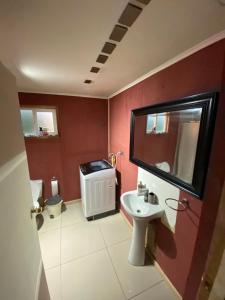 Un baño con lavabo, inodoro y espejo. en Departamento francisca, en Tey