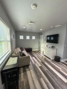 Modern Tampa studio full Kitchen & great location في تامبا: غرفة معيشة مع أريكة وتلفزيون بشاشة مسطحة