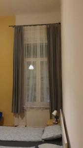 Un dormitorio con una cama y una ventana en Cozy rooms near the New York cafe, en Budapest