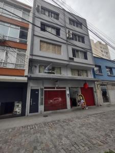 a building on a street next to a cobblestone street at Apto studio 302 centro de Florianópolis in Florianópolis