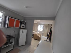 a kitchen with a refrigerator and a living room at Apto studio 302 centro de Florianópolis in Florianópolis