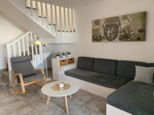 un soggiorno con un divano e una sedia di Casa 3 Soles a Morro del Jable