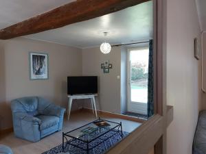 Μια τηλεόραση ή/και κέντρο ψυχαγωγίας στο Gîte chaleureux avec jardin arboré, terrasse, salle de jeux et parking privé à Pré-Saint-Évroult. - FR-1-581-3