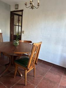 a dining room table and chairs with a table and a chandelier at Casa Puna in Alta Gracia +1 photo