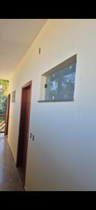 a white wall with a window in a room at Pousada do Barão in Lindóia