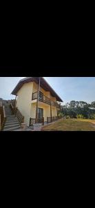 a building with a porch and stairs in front of it at Pousada do Barão in Lindóia