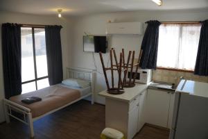 a small room with a bed and a kitchen at Miners Rest Units in Mount Magnet