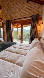 Pousada Vista do Céu في مونتي فيردي: غرفة نوم بسرير كبير ونافذة كبيرة