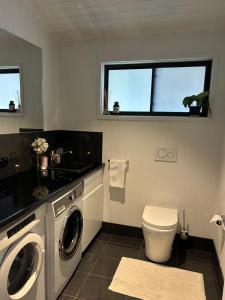 a bathroom with a washing machine and a toilet at Byron Bay Hinterland Sanctuary in Federal