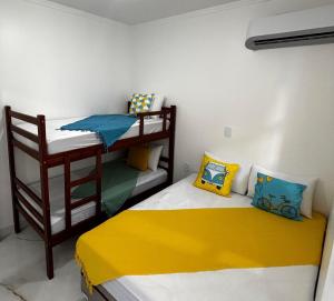 two bunk beds in a room with a yellow and blue at Aquarela Flats in Piranhas