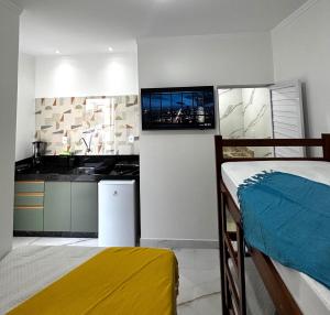 a room with a bed and a kitchen with a television at Aquarela Flats in Piranhas +17 photos