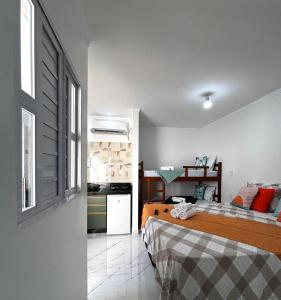 een kleine slaapkamer met 2 bedden en een keuken bij Aquarela Flats in Piranhas