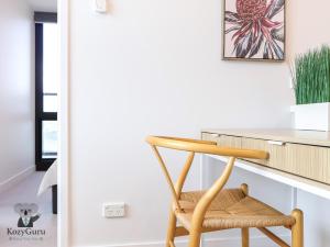 a wooden chair sitting in front of a desk at KozyGuru | Box Hill | Elegant City Hideaway in Box Hill +17 photos