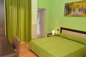 a green bedroom with a bed and a painting on the wall at B&B Fiori di Lava in Nicolosi