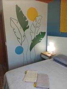 una camera da letto con un letto con due asciugamani sopra di A Casa Amarela - Morada dos Maçaricos - Tranquilidade próxima ao mar a Balneário Gaivotas