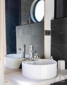 un bagno con un lavandino bianco e uno specchio di Casas Arco Jardin a Castro