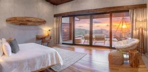 a bedroom with a bed and a balcony with a view at Lamangata Luxury Surf Resort in Dominical +16 photos