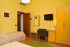 a hotel room with a desk and a bed and a computer at B&B Fiori di Lava in Nicolosi