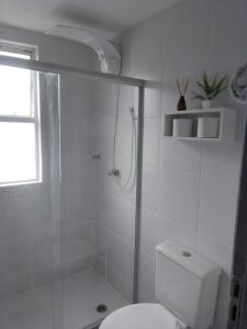 a white bathroom with a shower and a toilet at Apartamento no centro do Rio Vermelho-Ondina in Salvador +19 photos