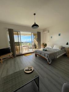 a bedroom with a bed and a table and a balcony at Cozy du Grand Large in Papeete +13 photos