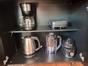 a kitchen shelf with a coffee maker and a blender at Studio Carimã Foz in Foz do Iguaçu