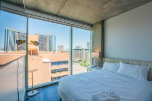 a bedroom with a bed and a large window at Panoramic Studio-1BR-3BR, Pool, Gym, Parking, Patio, BBQ in Phoenix +291 photos