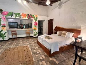 Un dormitorio con una cama, una mesa y un televisor. en Kika Zaru Free MA Park Tour & Breakfast, en Manuel Antonio