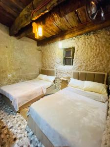 锡瓦Siwa Bait Ward Home的石头建筑中带三张床的房间