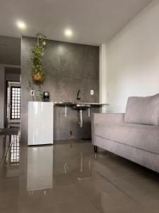 een woonkamer met een bank en een wastafel bij Oásis 6 prática e bem localizada e minimalista in Brasilia