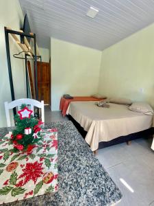ein Zimmer mit 2 Betten und einem Weihnachtsbaum auf einem Tisch in der Unterkunft Mini casa perto BC, Penha in Itajaí