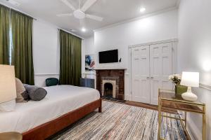 a bedroom with a bed with a fireplace and a tv at Nesting Escapes at Abercorn in Savannah